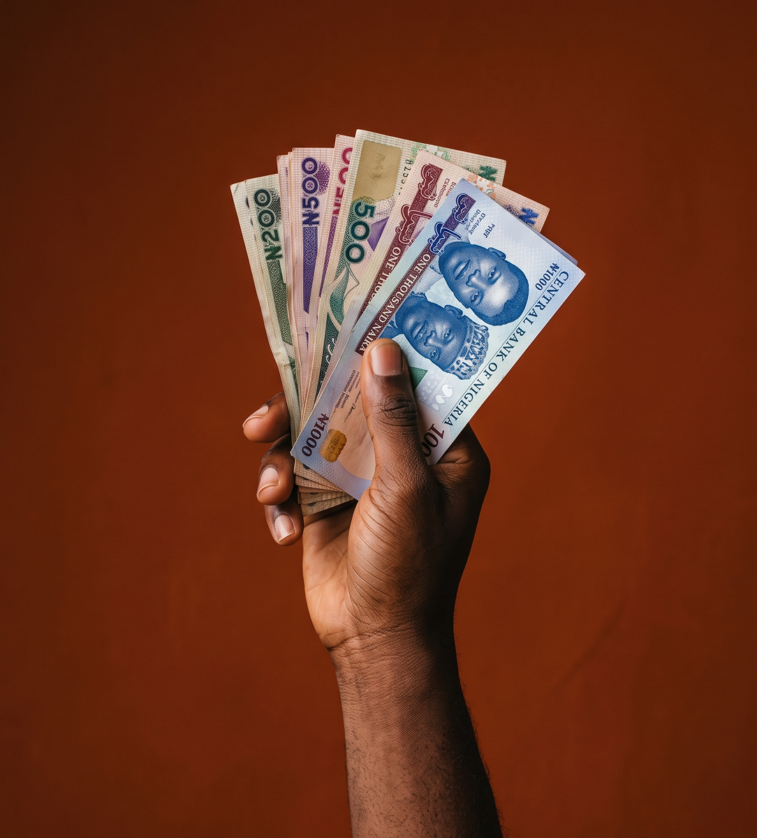 A hand holding some Naira notes